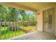 A covered balcony overlooks a well-maintained green lawn and mature trees, with a door leading inside at 4780 W 102Nd Pl, Westminster, CO 80031