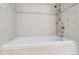 A tiled bathtub with modern fixtures, featuring a stylish shower head and neutral-toned tile at 4780 W 102Nd Pl, Westminster, CO 80031