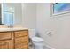 Bathroom with wood vanity, tile floor, toilet and mirror at 4780 W 102Nd Pl, Westminster, CO 80031