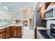 Open kitchen showcasing stainless steel appliances and a view into the living area and stairway at 4780 W 102Nd Pl, Westminster, CO 80031