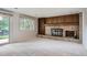 Cozy living room with brick fireplace, built-in shelves, sliding glass doors to the backyard, and neutral carpet at 4780 W 102Nd Pl, Westminster, CO 80031