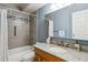 Updated bathroom with granite countertop, wooden vanity, and tiled shower over tub at 350 S Clinton St # 9C, Denver, CO 80247