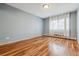 Comfortable bedroom with hardwood flooring, large window, and light blue walls at 350 S Clinton St # 9C, Denver, CO 80247