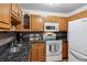 Well-lit kitchen featuring granite countertops, and wood cabinets, and modern appliances at 350 S Clinton St # 9C, Denver, CO 80247