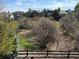 Scenic backyard view with mature trees, and a glimpse of neighborhood homes in the distance at 12380 Jasper Pointe Way, Castle Pines, CO 80108