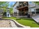 Spacious backyard featuring a deck, patio, playground, and lush artificial turf at 12380 Jasper Pointe Way, Castle Pines, CO 80108