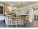 The bar area has stone accents, hanging lights, wooden bar stools, and storage at 12380 Jasper Pointe Way, Castle Pines, CO 80108