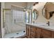 Bathroom featuring a glass shower, double vanity and large mirror at 12380 Jasper Pointe Way, Castle Pines, CO 80108