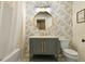 Stylish bathroom with a modern vanity, gold fixtures, and floral wallpaper at 12380 Jasper Pointe Way, Castle Pines, CO 80108