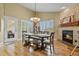 Cozy dining room with stone fireplace, wood floors, and decorative chandelier at 12380 Jasper Pointe Way, Castle Pines, CO 80108