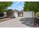 Spacious driveway leading to a three car garage, surrounded by lush greenery and brick facade at 12380 Jasper Pointe Way, Castle Pines, CO 80108