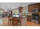 Modern kitchen with dark wood cabinets, stainless steel appliances, and island seating at 12380 Jasper Pointe Way, Castle Pines, CO 80108