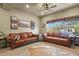 The cozy living room features hardwood floors, large window for natural light, and comfortable leather sofas at 12380 Jasper Pointe Way, Castle Pines, CO 80108