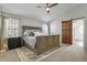 Spacious main bedroom with a large bed, ceiling fan, and a barn door to bathroom at 12380 Jasper Pointe Way, Castle Pines, CO 80108
