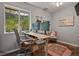 Bright home office featuring dual monitors, a sit-stand desk, and a garden view at 12380 Jasper Pointe Way, Castle Pines, CO 80108