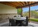 Covered outdoor dining area with comfortable seating and views of the backyard at 12380 Jasper Pointe Way, Castle Pines, CO 80108