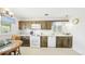 Cozy kitchen features wooden cabinets, white appliances, and a dining area at 1930 Taft Dr, Lakewood, CO 80215