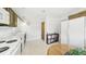 A bright kitchen featuring white appliances and cabinets, plus a round table for casual dining at 1930 Taft Dr, Lakewood, CO 80215
