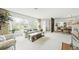 An open floor plan showcasing a living room, fireplace and dining area filled with natural light at 1930 Taft Dr, Lakewood, CO 80215