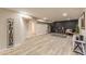 Finished basement featuring light wood floors, painted brick accent wall, and modern decor at 2274 S Cherry St, Denver, CO 80222