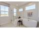 Luxurious bathroom features a soaking tub, glass shower, and large window offering natural light and serene views at 14128 Bunny Hop Ln, Parker, CO 80134