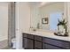 Bright bathroom featuring a single vanity with a quartz countertop, framed mirror, and shower-tub combination at 14128 Bunny Hop Ln, Parker, CO 80134