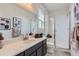 Modern bathroom with a white countertop, dark cabinets, glass-enclosed shower and large mirror at 14128 Bunny Hop Ln, Parker, CO 80134