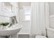 Bright bathroom features a shower-tub combination, white tiling, and stylish fixtures at 2641 N Clayton St, Denver, CO 80205