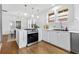 The open kitchen has stainless steel appliances, white cabinets, and hardwood floors at 2641 N Clayton St, Denver, CO 80205