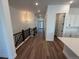 Spacious hallway with wood floors, modern lighting, and access to the kitchen and front door at 1111 Joseph Pl, Erie, CO 80026