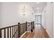 Bright hallway featuring wood floors, a chandelier, and neutral wall paint at 1111 Joseph Pl, Erie, CO 80026