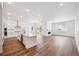 Open kitchen and living area featuring white cabinetry, quartz countertops, and wood floors at 1111 Joseph Pl, Erie, CO 80026
