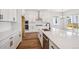 Modern kitchen featuring white cabinetry, quartz countertops, stainless steel appliances, and wood-look flooring at 1111 Joseph Pl, Erie, CO 80026