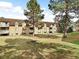 Apartment building with grassy backyard, picnic table, and trees at 7455 E Quincy Ave # 101, Denver, CO 80237