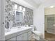 Bathroom with gray vanity, patterned wallpaper, and a closet at 7455 E Quincy Ave # 101, Denver, CO 80237