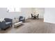 Living room with gray armchairs, a small table, and light wood floors at 7455 E Quincy Ave # 101, Denver, CO 80237