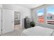 Bright bedroom with a black dresser, two windows, and an open door leading to the bathroom at 22043 E 38Th Pl, Aurora, CO 80019