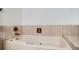 Elegant soaking tub features decorative tile surround and vintage hardware at 9270 Tennyson St, Westminster, CO 80031