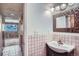 Cozy bathroom featuring vintage pink tile, a vanity with a sink, and a hallway view at 9270 Tennyson St, Westminster, CO 80031