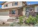 Close-up of the home's entrance with a decorative door, brick accents, and flower bed at 9270 Tennyson St, Westminster, CO 80031