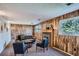 Inviting living room features wood paneling, a cozy fireplace, and plenty of natural light from the large windows at 9270 Tennyson St, Westminster, CO 80031