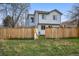 View of fenced backyard and two-story home with blue trim on a sunny day at 9521 Joyce Ln, Highlands Ranch, CO 80126