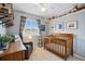 Bedroom with wood crib, chair, and whimsical decor, with natural light streaming through a large window at 9521 Joyce Ln, Highlands Ranch, CO 80126