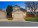 Exterior shot of home with a two-car garage, lighting, and manicured lawn at 9521 Joyce Ln, Highlands Ranch, CO 80126