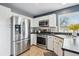 The kitchen features stainless steel appliances, white cabinets and tile flooring at 9521 Joyce Ln, Highlands Ranch, CO 80126