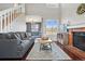 Open-concept living space features a brick fireplace, modern decor, and staircase at 9521 Joyce Ln, Highlands Ranch, CO 80126