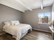 Bright bedroom featuring exposed beam ceiling, hardwood floors, and a large window with a neighborhood view at 384 S Ironton St # 408, Aurora, CO 80012