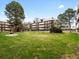 Well maintained condominium community featuring a manicured lawn and mature trees under a clear blue sky at 384 S Ironton St # 408, Aurora, CO 80012