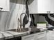Close up of the kitchen sink with stainless steel fixtures and striking black and white marble backsplash at 384 S Ironton St # 408, Aurora, CO 80012