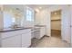 Elegant bathroom featuring double vanity sinks, modern fixtures, tile flooring, and a walk-in closet at 739 N Deer Park St, Watkins, CO 80137